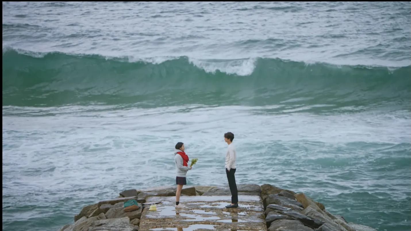 Eun-tak and the Goblin standing on Jumunjin breakwater facing each other