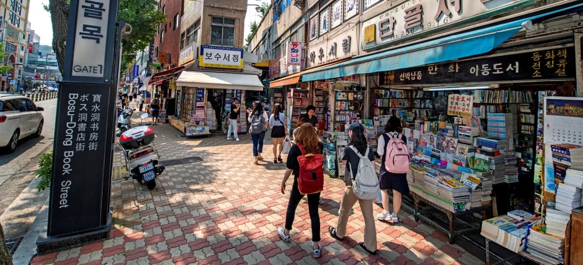 Bosu-dong Book Street Gate 1 entrance with stone marker and used bookstore stalls along the alley