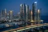 Marine City Busan skyline at dusk with lit high-rise towers, the yacht marina, and Gwangandaegyo Bridge in the foreground