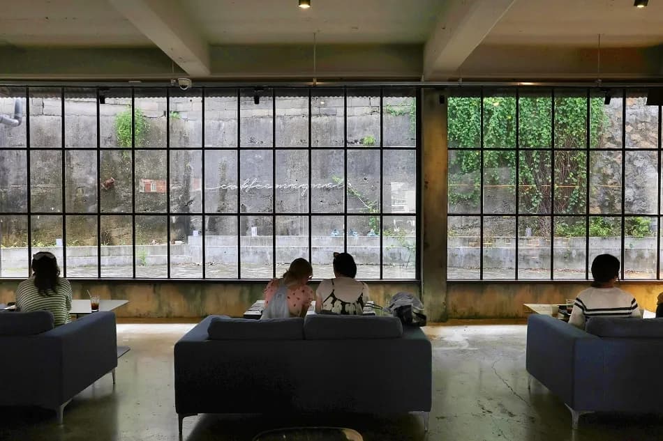 ZM-illennial cafe interior with industrial factory windows and seating area in Nam-gu, Busan