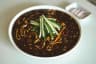 Bowl of jajangmyeon with black bean sauce and fresh cucumber garnish