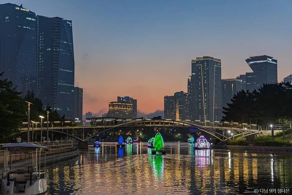 Songdo Central Park seawater canal at sunset with LED sculptures and Incheon skyline