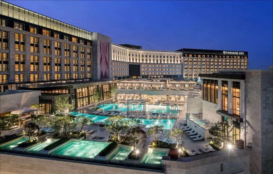 Paradise City resort pool and towers lit at dusk