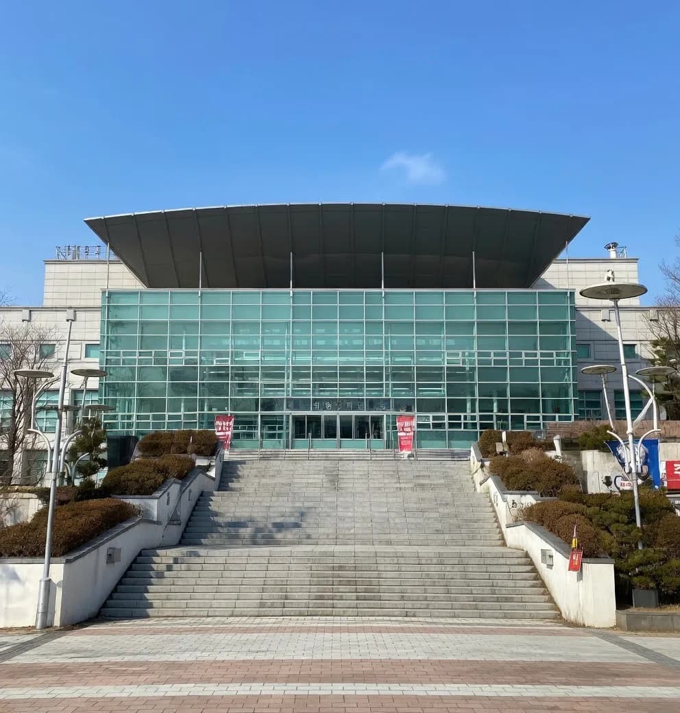 Korea University Hwajeong Gymnasium exterior with glass facade and staircase