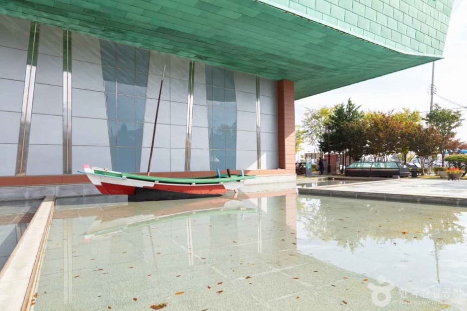 Gunsan Modern History Museum building beside a traditional boat at the inner port