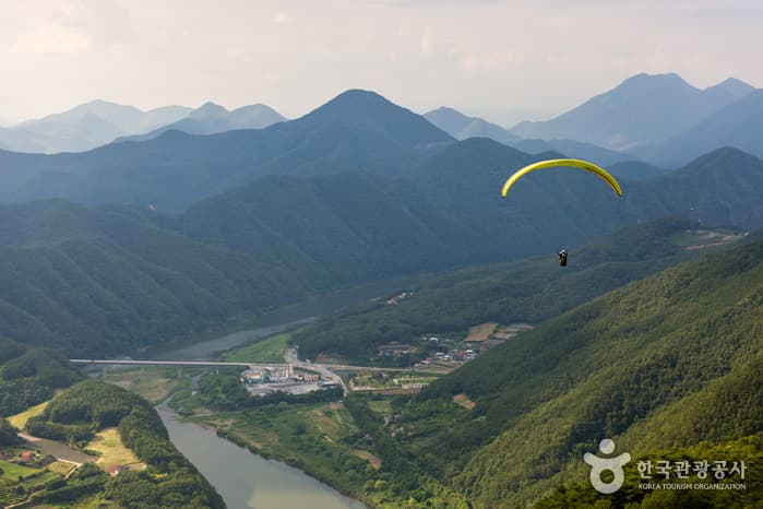 Paraglider launching from Yangbangsan summit overlooking the Namhan River in Danyang