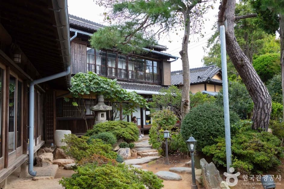 Garden and stone lantern beside the wooden Hirotsu House in Gunsan
