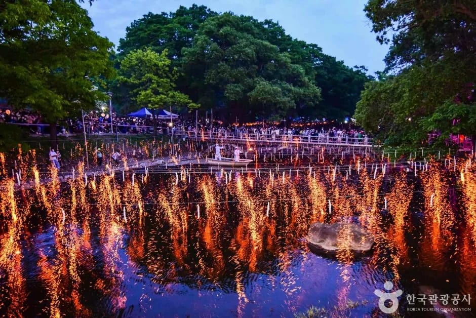 Wide view of Haman Nakhwanori festival with hundreds of burning rods reflected in water