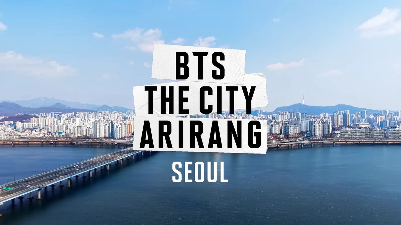BTS THE CITY ARIRANG SEOUL title card from the official BANGTANTV film, Seoul skyline over the Han River