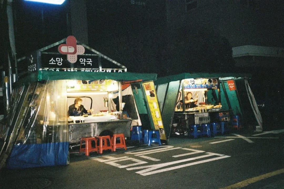 Korean pojangmacha tent restaurants with warm orange glow at night