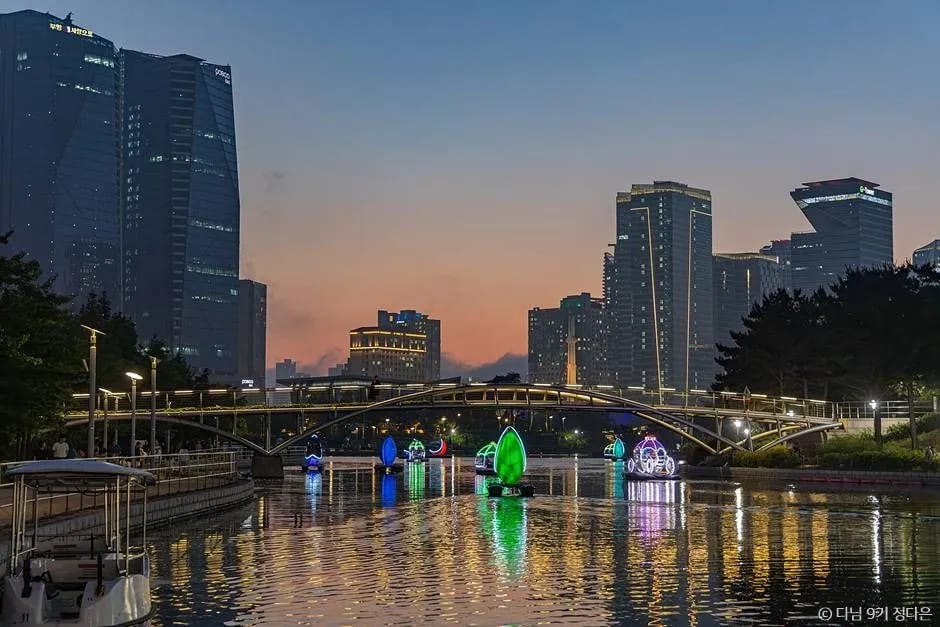 Songdo Central Park seawater canal at sunset with LED sculptures and Incheon skyline