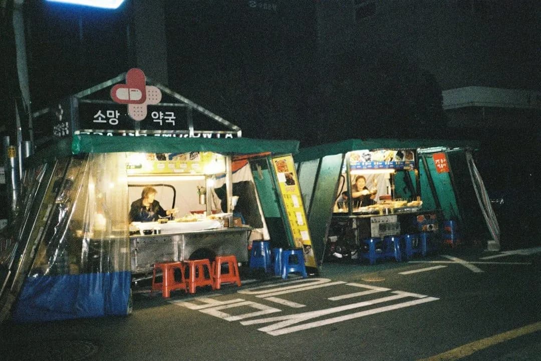 Korean pojangmacha tent restaurants with warm orange glow at night